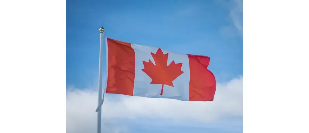 Canadian flag waving against a blue sky, representing Canada study permit applications