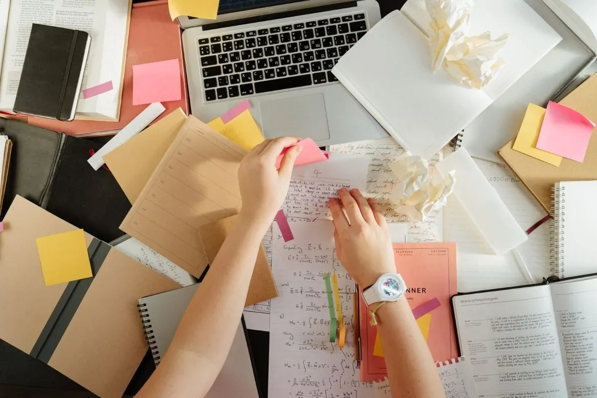 Student organizing F-1 visa paperwork and deadlines with a laptop and notes