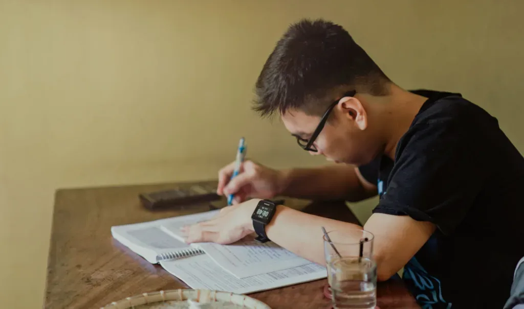 Indian student writing and studying, preparing a study abroad application despite backlogs
