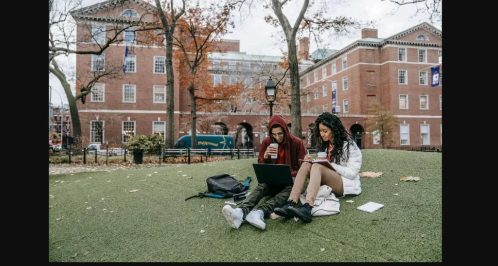 Two international students studying together on a US university campus lawn