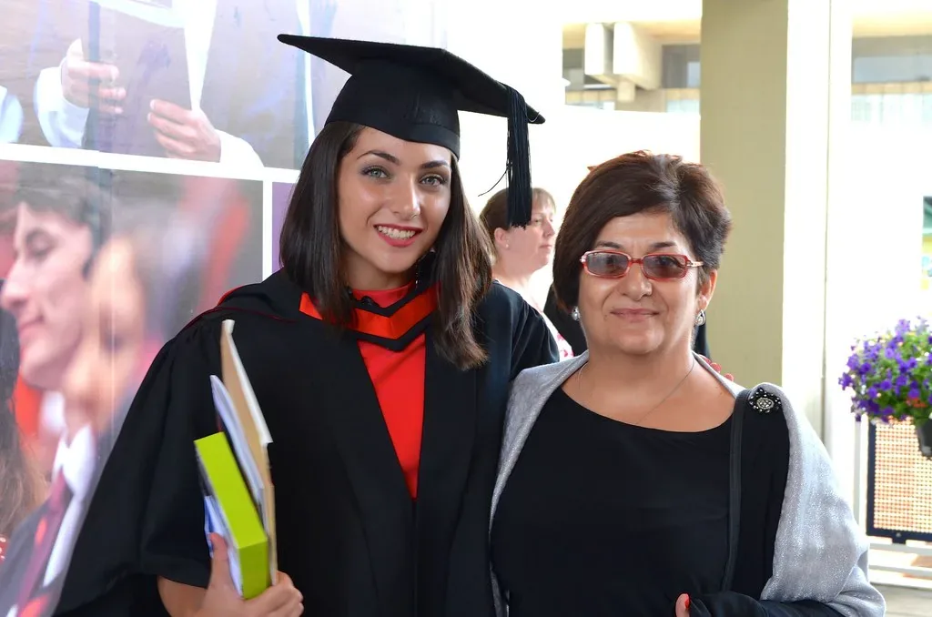 Graduates in caps and gowns celebrating at a university graduation ceremony